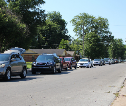 Cars wait in line at a food distribution